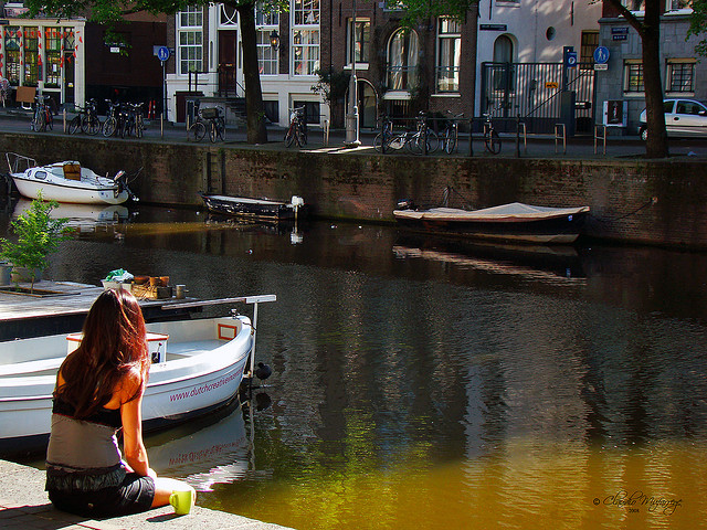 girl sitting on canal in Amsterdam