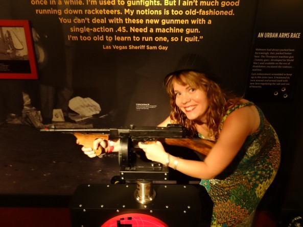 girl posing with machine gun inside the mob museum in las vegas