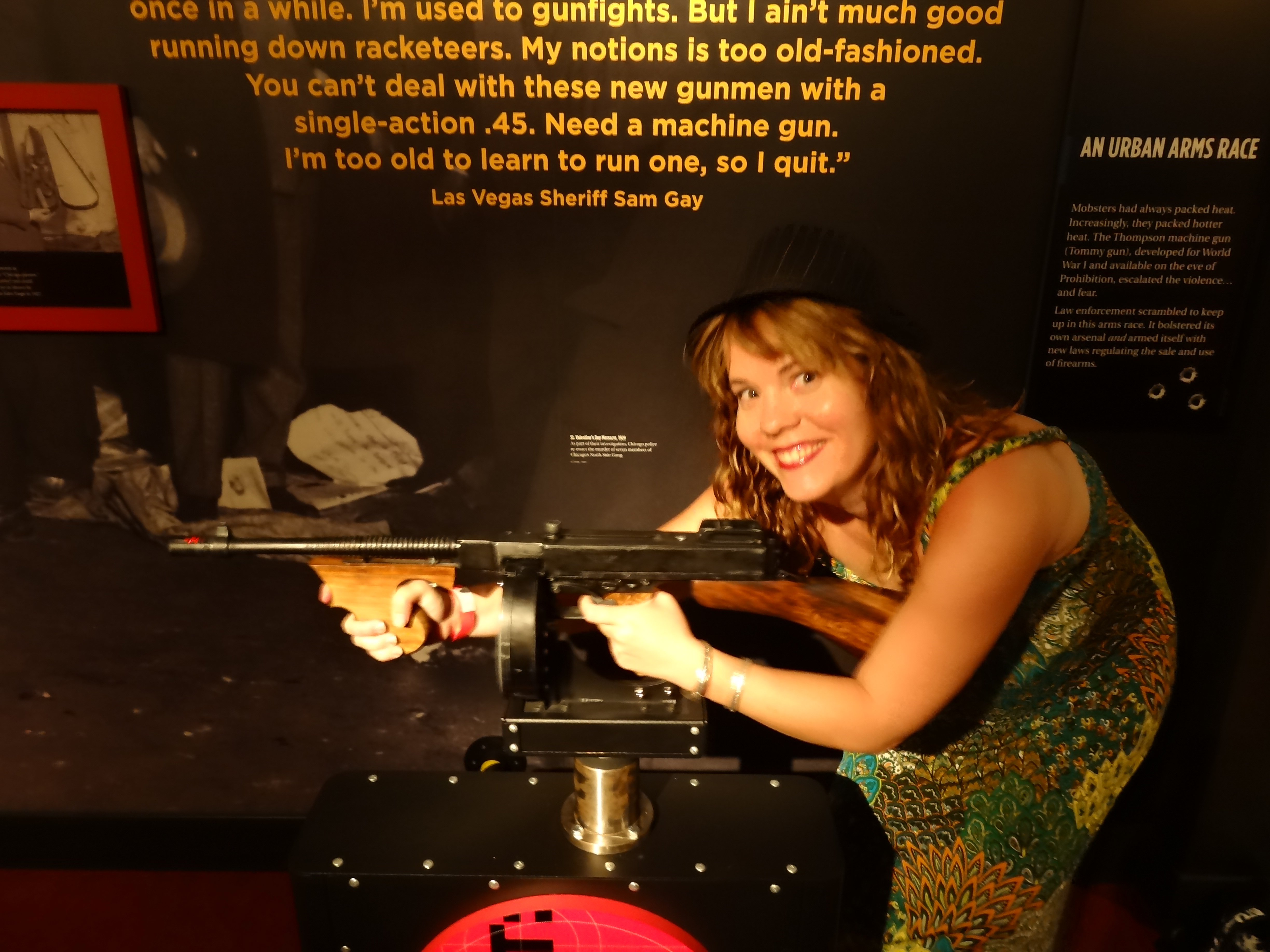 girl posing with machine gun inside the mob museum in las vegas