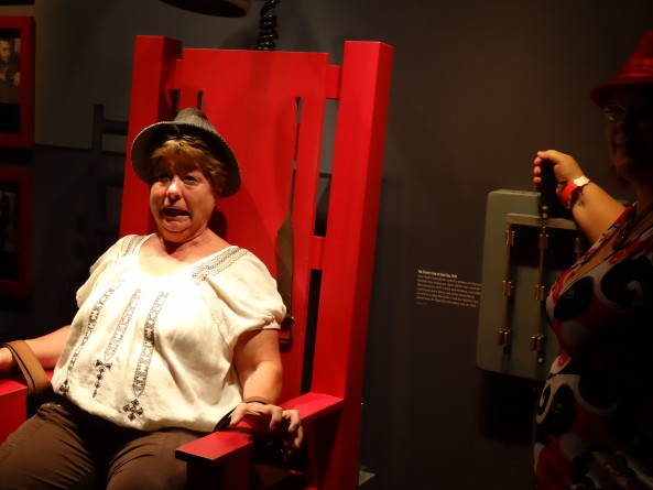 woman sitting in fake electric chair in mob museum in las vegas