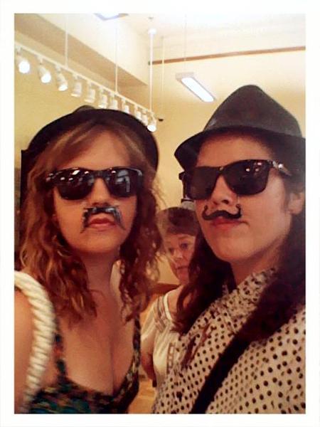 two girls with glasses and fake moustaches