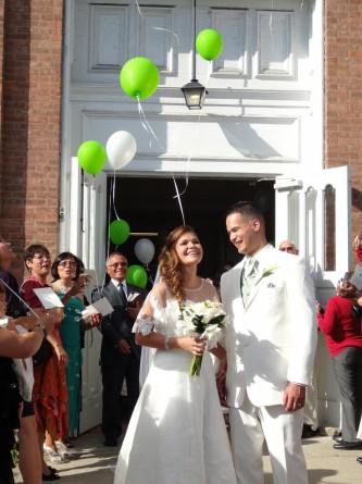 bride and groom leaving church and releasing balloons