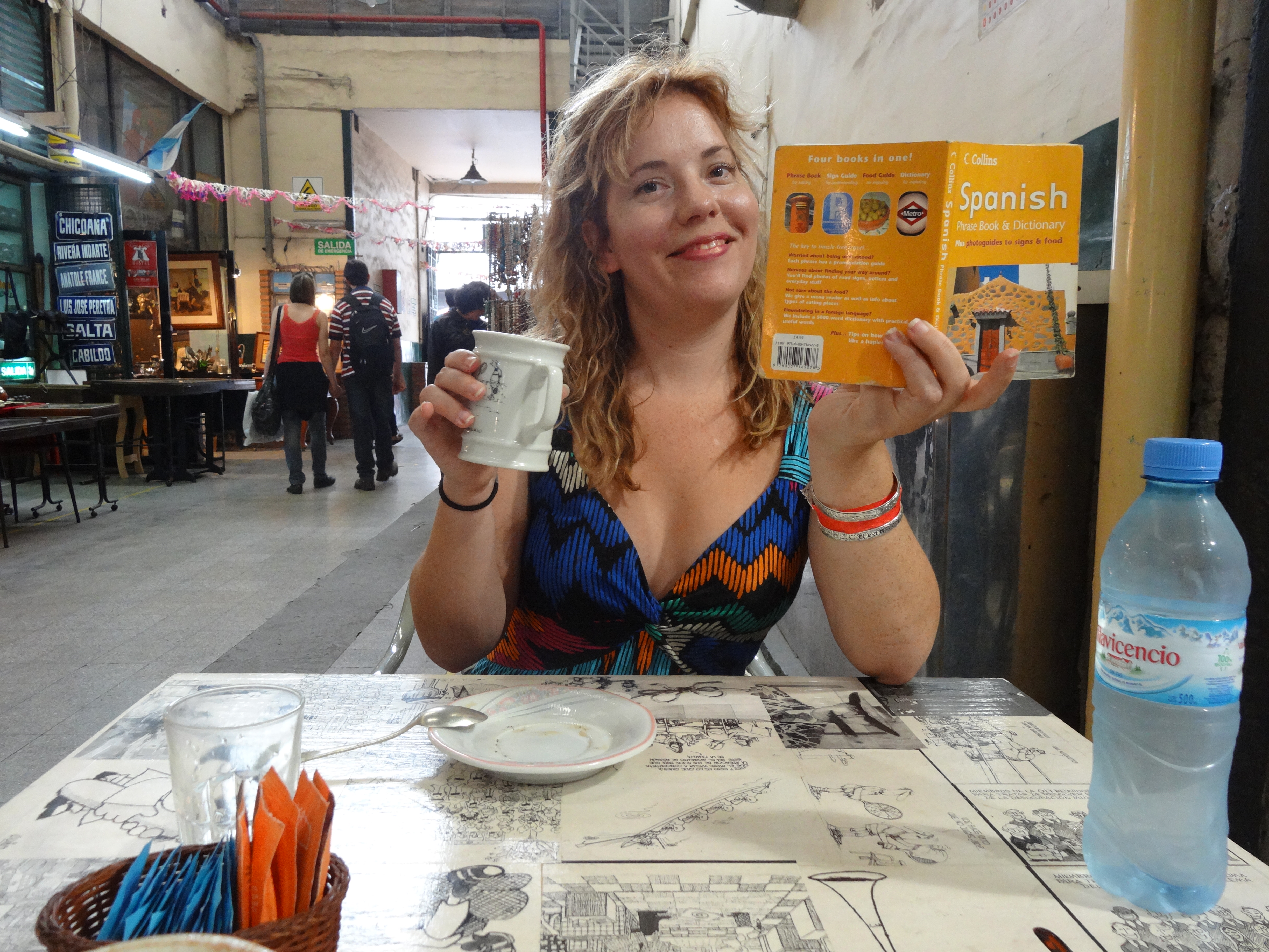 reannon sipping coffee and reading a Spanish language phrase book in buenos aires